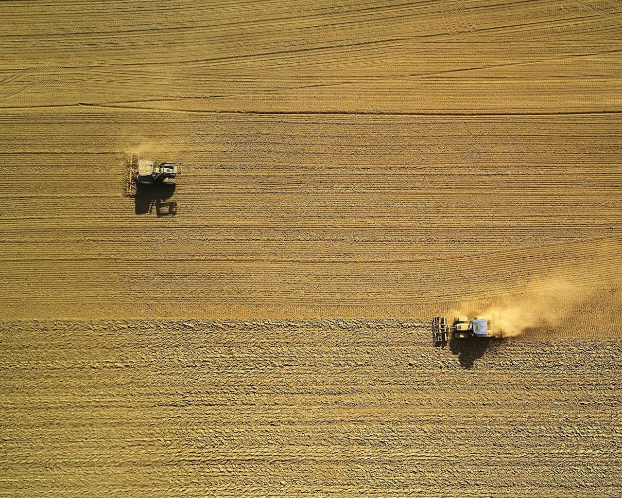Vue aérienne de tracteurs en train d'intervenir dans un champ