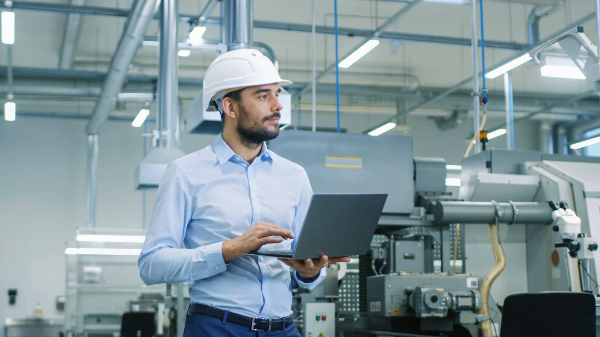 Technicien utilisant un ordinateur dans un environnement industriel