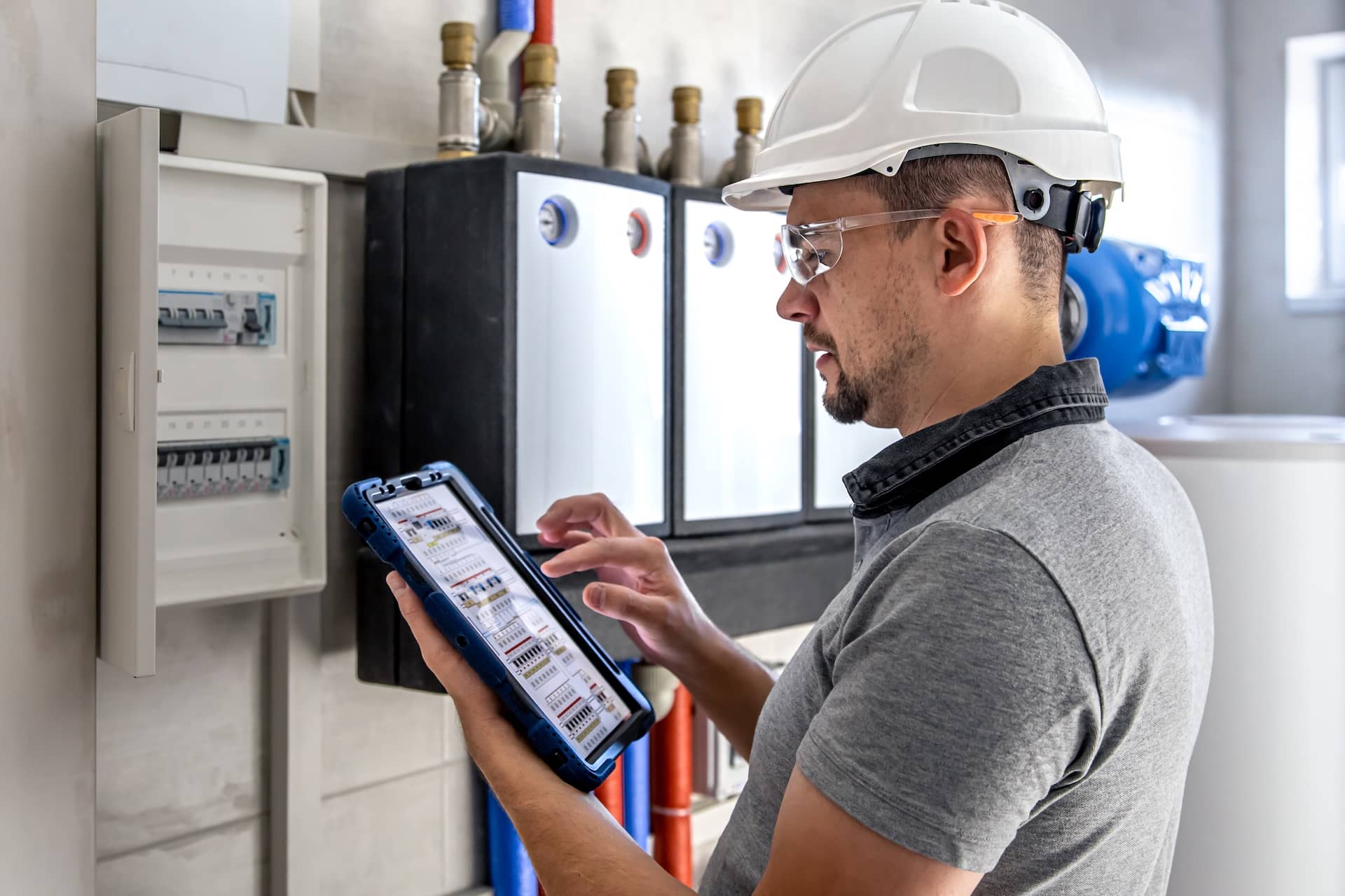 Technicien contrôlant le bon fonctionnement d'une installation électrique depuis sa tablette